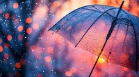 Transparent umbrella with raindrops against blurred bokeh lights in pink and blue tones creates dreamy atmospheric mood for romantic and rainy evening concepts.