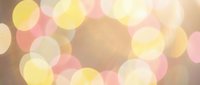 Soft bokeh lights background with warm golden yellow and pink circles creating dreamy atmosphere for romantic designs and elegant presentations.