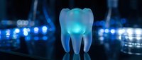 Glowing translucent tooth model with blue illumination on dark background with bokeh lights for dental healthcare and medical education concepts.