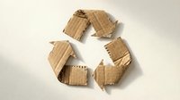 Recycling symbol made from torn cardboard pieces on white background, representing sustainable packaging, environmental conservation, and circular economy concepts for eco-friendly design projects.