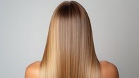 Straight blonde hair with smooth gradient ombre effect from dark roots to light ends shown from behind on neutral background, demonstrating professional hair coloring technique.