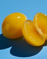 Fresh raw egg yolks on blue background with dramatic shadows, close-up macro photography showing texture and natural golden color for culinary and food concepts.