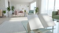 Open blank book on glass table in bright modern living room with soft pastel furniture and green plants in background, copy space.