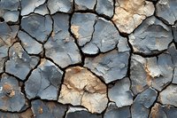 Cracked and peeling paint texture on weathered surface showing layers of blue and brown colors with natural aging patterns for backgrounds.