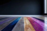 Colorful wooden floor planks in rainbow spectrum colors against dark background, featuring vibrant blue, purple, natural wood, and pink tones. Modern interior design element.