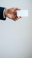 Businessman in dark suit holding blank white card isolated on light background, ready for contact information or branding mockup.