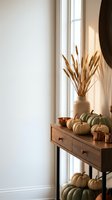 Cozy autumn home interior with pumpkins and wheat stalks on wooden console table by window for seasonal decoration and fall harvest styling.