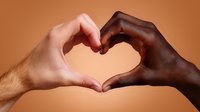 Diverse hands forming heart shape against brown background, symbolizing unity, love, acceptance and racial harmony in modern society.