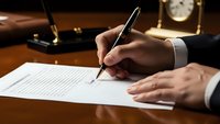 Professional businessman signing important legal contract document with elegant pen at executive wooden desk in warm office lighting.