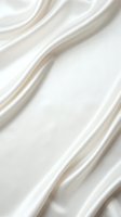Luxurious cream silk fabric with flowing waves and soft folds creating elegant draping texture for fashion and interior design projects.