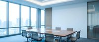 Modern corporate boardroom with large conference table and ergonomic chairs overlooking city skyline through floor-to-ceiling windows for business meetings.