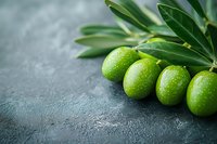 Fresh green olives with water drops and leaves on dark stone background, macro food photography for restaurant menu and healthy cooking concept.