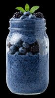 Blueberry and blackberry chia pudding in a glass jar, topped with fresh mint, isolated on transparent background. For stickers, menus, t-shirt design, print on demand.
