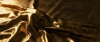Luxurious golden silk fabric with rich folds and dramatic lighting, perfect for fashion, textile, and luxury design projects.
