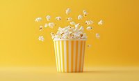 Flying popcorn from striped yellow and white container on bright yellow background. Fresh popped kernels floating in air create dynamic composition.