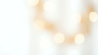 Soft golden bokeh lights creating dreamy abstract background with warm glowing circles and gentle blur effects for elegant design projects.