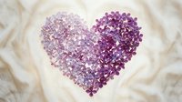Lilac flowers arranged in a heart shape on soft cream fabric, gradient from pale lavender to deep purple, romantic floral composition.