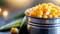 Fresh cooked chickpeas in metal bowl with olive oil and herbs against dark background with bokeh lights, macro food photography.