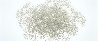 Sparkling silver glitter particles scattered on white background for festive decorations, craft projects, makeup artistry and holiday celebrations.