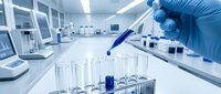 Laboratory scientist in blue gloves using pipette with test tubes in modern research facility for medical analysis and scientific experiments.