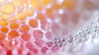 Macro photography of soap bubbles in pink and orange gradient colors creating abstract pattern with bokeh effect and selective focus for creative background.