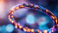 Glowing spiral light trail with vibrant blue and orange bokeh effects creates magical atmosphere against dark background, suitable for abstract design projects.