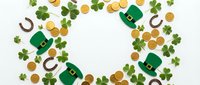 St. Patrick's Day festive frame with green leprechaun hats, four-leaf clovers, golden coins and horseshoes on white background for holiday greeting cards.