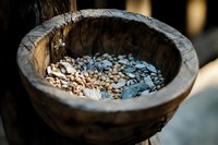 Rustic wooden bowl filled with raw coffee beans showcasing natural textures and warm lighting for cafe and agricultural themes.