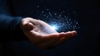 Magical glowing particles and sparkles floating above open palm in dark background creating mystical ethereal atmosphere. Concept of hope, dreams and spirituality.