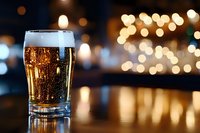 Glass of sparkling cola with ice cubes on wooden table against blurred bokeh lights at night, suitable for beverage advertising and restaurant promotions.
