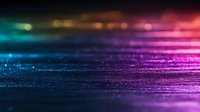 Colorful glowing abstract background with gradient from blue to pink and purple colors, blurred bokeh lights and sparkle effect on dark surface.