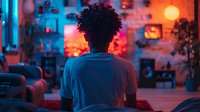 Young African American man with curly hair silhouette in modern apartment with neon lighting and orange sunset glow through window, creating moody atmospheric ambiance.