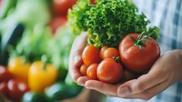 Fresh ripe tomatoes and green lettuce in hands against blurred vegetables background, healthy eating and organic produce concept for food design.