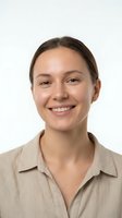 Young woman with brown hair and fair complexion wearing a beige collared shirt, smiling at camera against white background. Portrait for corporate profiles, business websites, team pages.