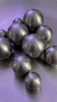 Cluster of metallic spheres with brushed silver finish and purple ambient lighting on reflective surface, suitable for abstract backgrounds and design projects.