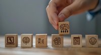 Wooden blocks with brain and business icons arranged in sequence showing strategic thinking and problem solving concept for corporate training and development.