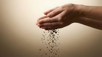 Hands releasing soil particles in cupped palms against neutral background, symbolizing environmental care, sustainability, agriculture, and earth conservation for ecological concepts.