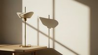 Minimalist brass table lamps with curved shades casting geometric shadows on wooden surface and neutral wall, contemporary interior design lighting.