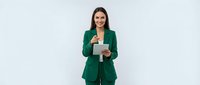 Professional businesswoman in green suit holding tablet computer smiling confidently against white background for corporate presentations and marketing.