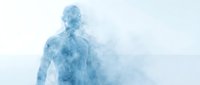 Young adult male with light skin tone dissolving into blue smoke and mist, representing transformation, digital technology, or abstract concepts for wellness and innovation projects.