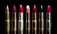 Luxury lipsticks in various shades of red, pink, and black with metallic gold and silver tubes arranged in row against dark background.