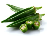 Fresh whole and sliced okra pods showing internal star pattern on white background, raw green vegetables for cooking and healthy eating.