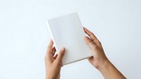 Hands holding blank white box or package against neutral background for branding, packaging design, product mockup, or advertising purposes.