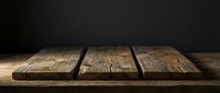 Rustic wooden table surface with natural grain texture against dark background for product display and food photography presentations.