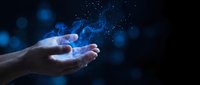Open hands holding glowing blue digital particles and light effects against dark background for technology and innovation concepts.