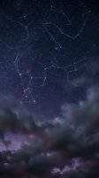 Night sky with glowing constellation lines over dramatic dark clouds, stars scattered across deep blue cosmic space.