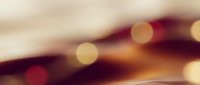 Blurred bokeh lights with warm golden and deep burgundy tones create an abstract, dreamy atmosphere suitable for backgrounds and design projects.