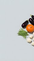 Fresh organic vegetables including eggplant, pumpkin, green beans and cauliflower arranged on neutral background with copy space for healthy cooking designs.