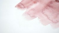Soft pink watercolor wash with organic flowing texture on white paper background for artistic projects and creative designs.