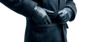 Male professional of mixed ethnicity wearing dark formal coat and black leather gloves, hands positioned at waist in confident stance, suitable for business, corporate, and professional contexts.